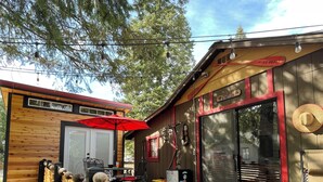 A wooden deck with a red umbrella, a wooden fence, and a building with a red awning and a sign that reads "O'NEILLS".