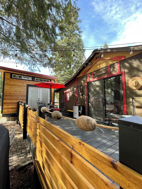 A wooden deck with a red umbrella, a wooden fence, and a building with a red awning and a sign that reads "O'NEILLS".
