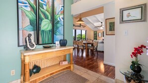 A dining area with a wooden console table, chairs, and a view of the kitchen. - 180 Degree Ocean View in Wailea! WE204 (Kihei)