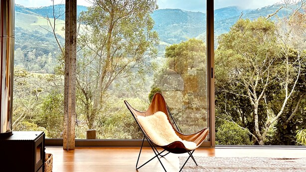 Ein Zimmer mit großem Fenster und Blick auf eine Berglandschaft.