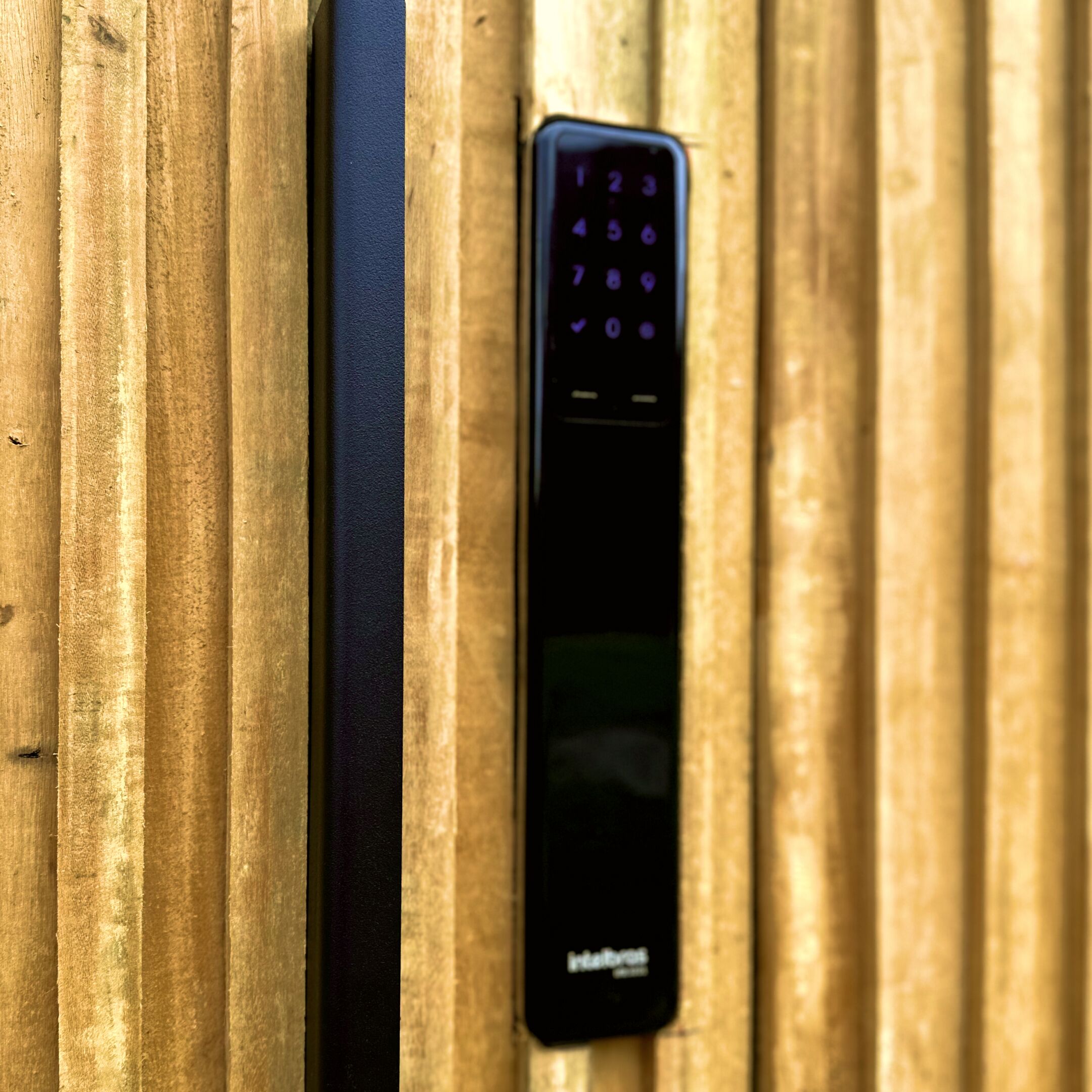Une télécommande noire dotée d’un pavé numérique, posée sur une surface en bois.