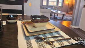 A dining area with a table set for two, featuring a bowl and cutlery. - Cozy 1-bedroom apartment in lovely St. Louis with WiFi, AC (St. Louis)