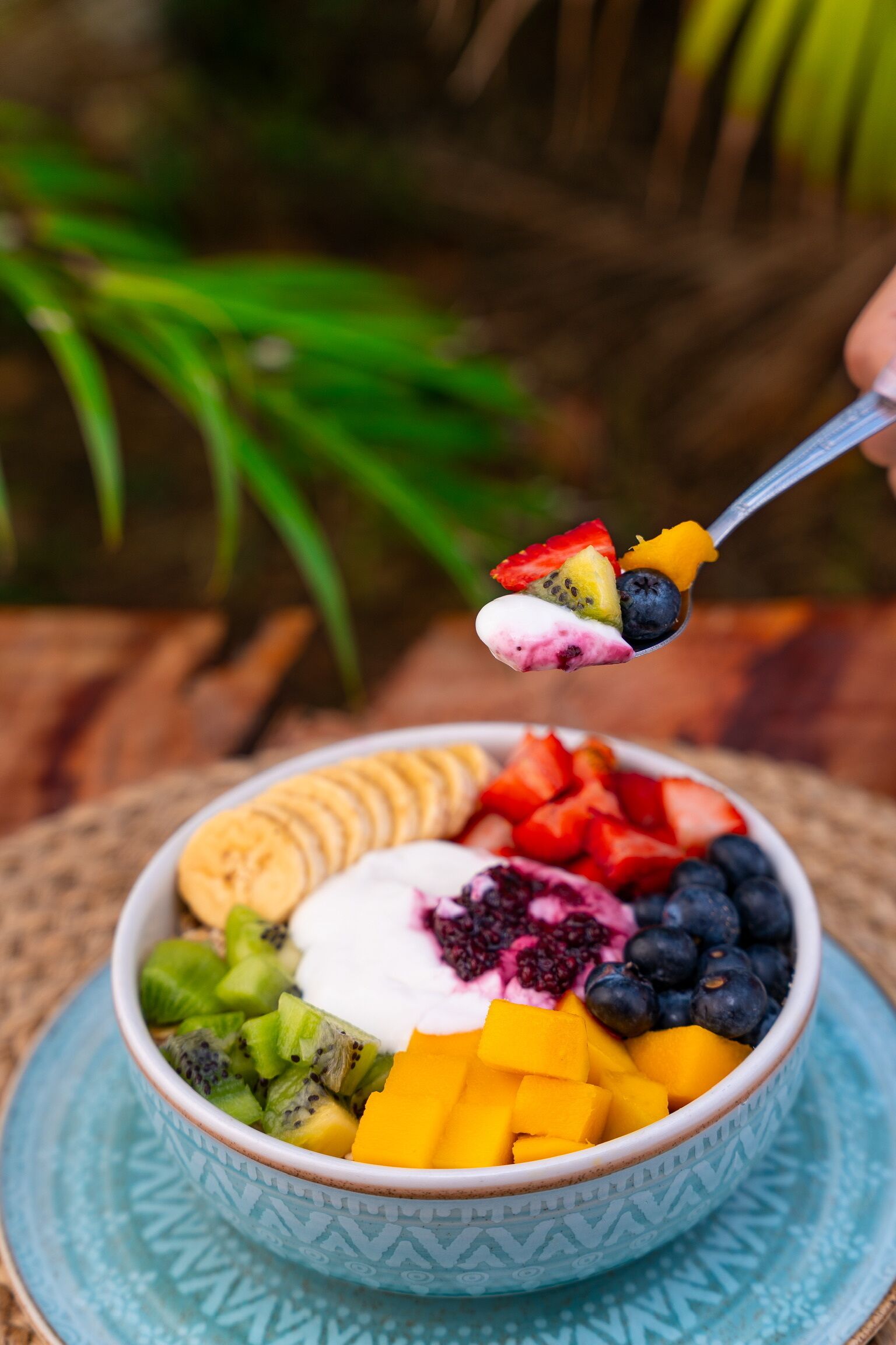 Un tazón de ensalada de frutas con diversas frutas y yogur.