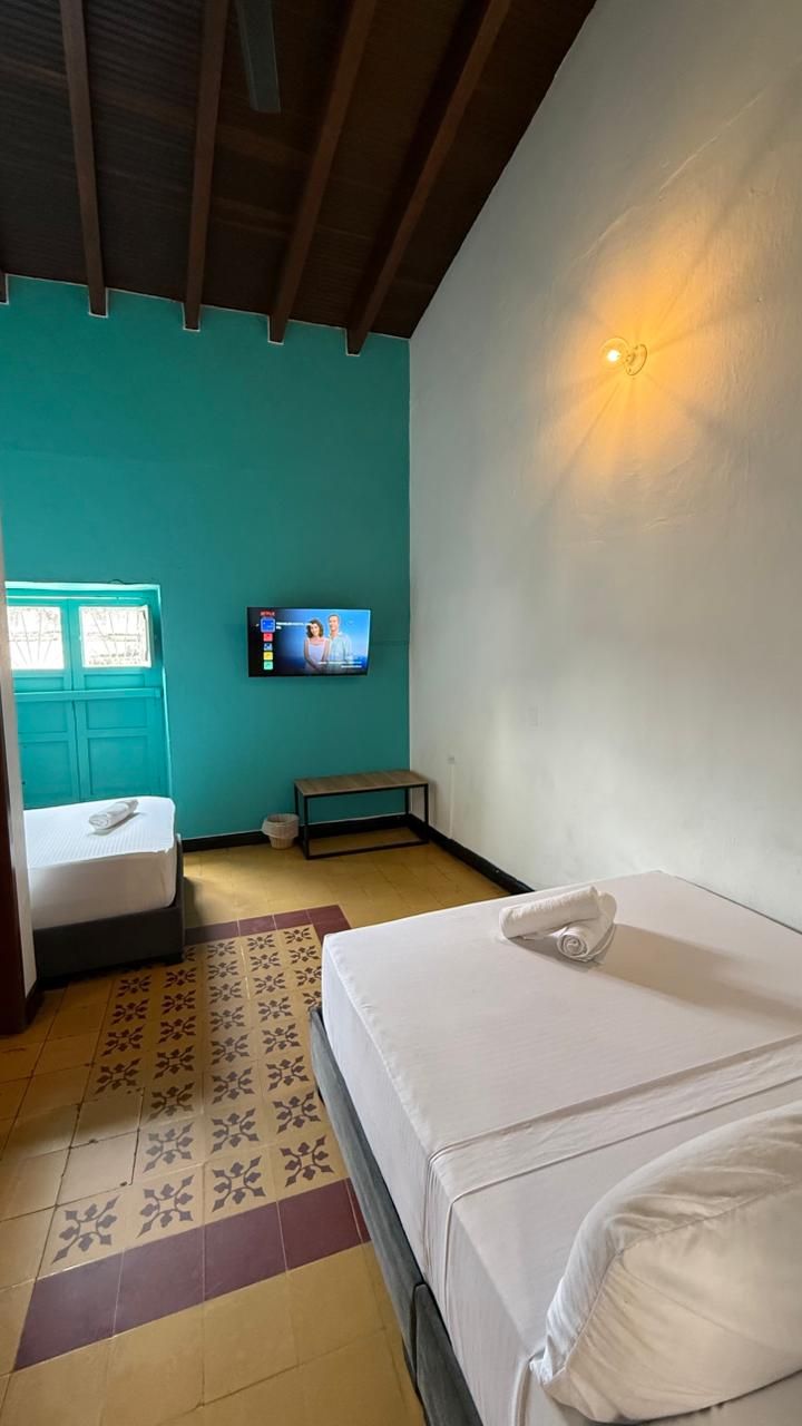 A hotel room with a bed, a bench, a television, and a window with a view.