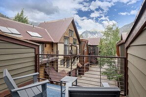 A residential building with multiple levels, a balcony with a metal railing, and a view of mountains in the background. - Telluride Resort View at Double Diamond - ski/in! (Telluride)