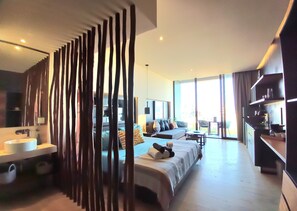 Une chambre d’hôtel moderne dotée d’un grand lit, d’un canapé, d’un coin repas et offrant une vue sur l’extérieur.