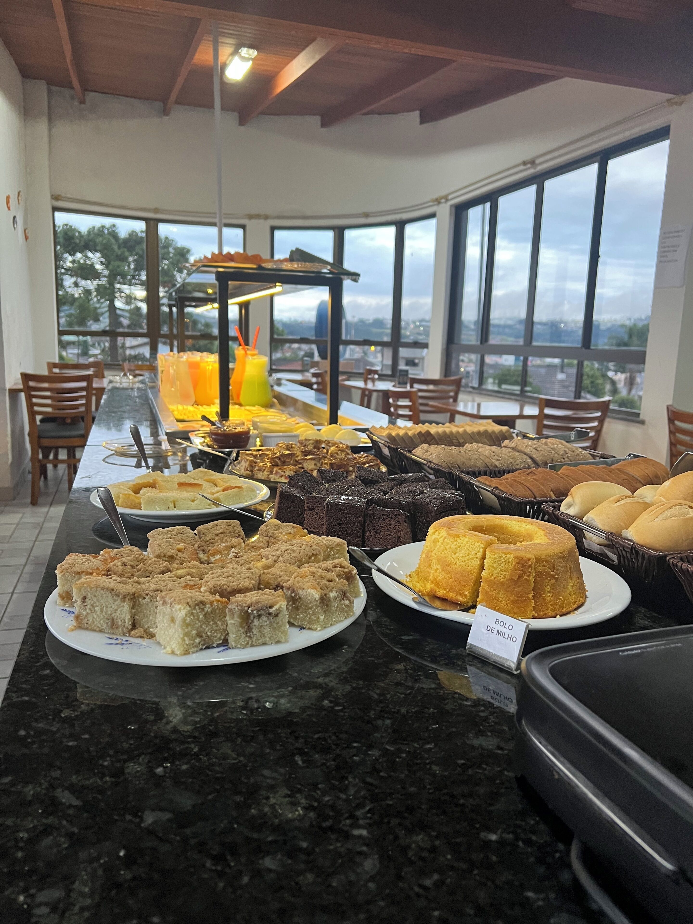 Buffet com diversos produtos de pastelaria e espaço para sumos.