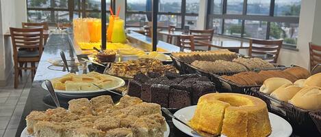 A buffet with various baked goods and a juice station.