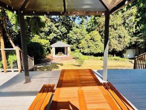 A wooden deck with a covered seating area and a gazebo in the background. - Charming 2BR w/ Garden Retreat & 2 Free Parking (Bothell)