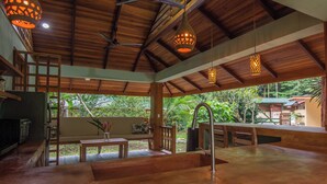 A spacious kitchen with a wooden countertop, a sink, and hanging pendant lights. - Tucan Chiquita Beach Casitas (Playa Chiquita)