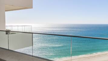 A balcony with a view of the ocean and beach.