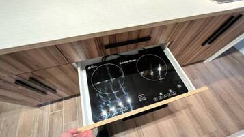 A kitchen with a built-in stove and a drawer with a handle.