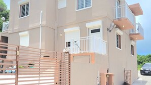 Ein mehrstöckiges Gebäude mit beiger Fassade, zahlreichen Fenstern mit Fensterläden und einem verschlossenen Eingang.