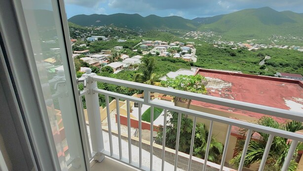 Ein Balkon mit Blick auf eine Stadt und Berge.