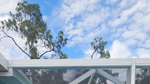 A hot tub with a glass enclosure, surrounded by a metal frame, and a red towel on the left. - Very Clean, Peaceful 3-bedroom house in tranquil North Port with AC, WiFi (North Port)