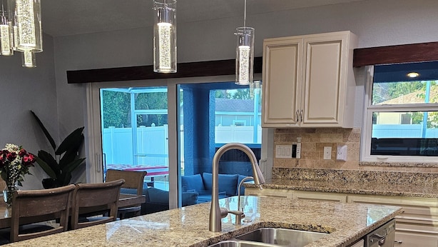 A kitchen with granite countertops, stainless steel appliances, and pendant lighting. - Very Clean, Peaceful 3-bedroom house in tranquil North Port with AC, WiFi (North Port)
