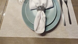 A dining table set with plates, cutlery, and a folded napkin. - Very Clean, Peaceful 3-bedroom house in tranquil North Port with AC, WiFi (North Port)