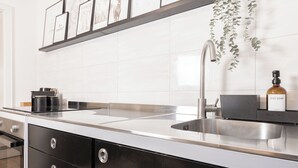 A modern kitchen with a stainless steel sink, black cabinets, and a coffee machine. - Mc´maggies Atelier mit Insgesamt 6 Schlafpl ätzen (Meerbusch)