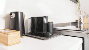 A modern kitchen with a coffee maker, a water dispenser, and a wooden box on the counter. - Mc´maggies Atelier mit Insgesamt 6 Schlafplätzen (Meerbusch)