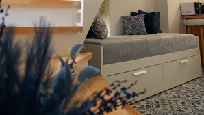 A modern staircase with wooden steps and white railings, leading to a seating area with patterned cushions. - Sapphire Zafeirenias Gem House With Jacuzzi (Hersonissos)