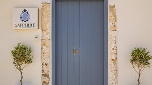 A modern building with a large blue door, two potted plants, and a sign that reads "Sapphire." - Sapphire Zafeirenias Gem House With Jacuzzi (Hersonissos)
