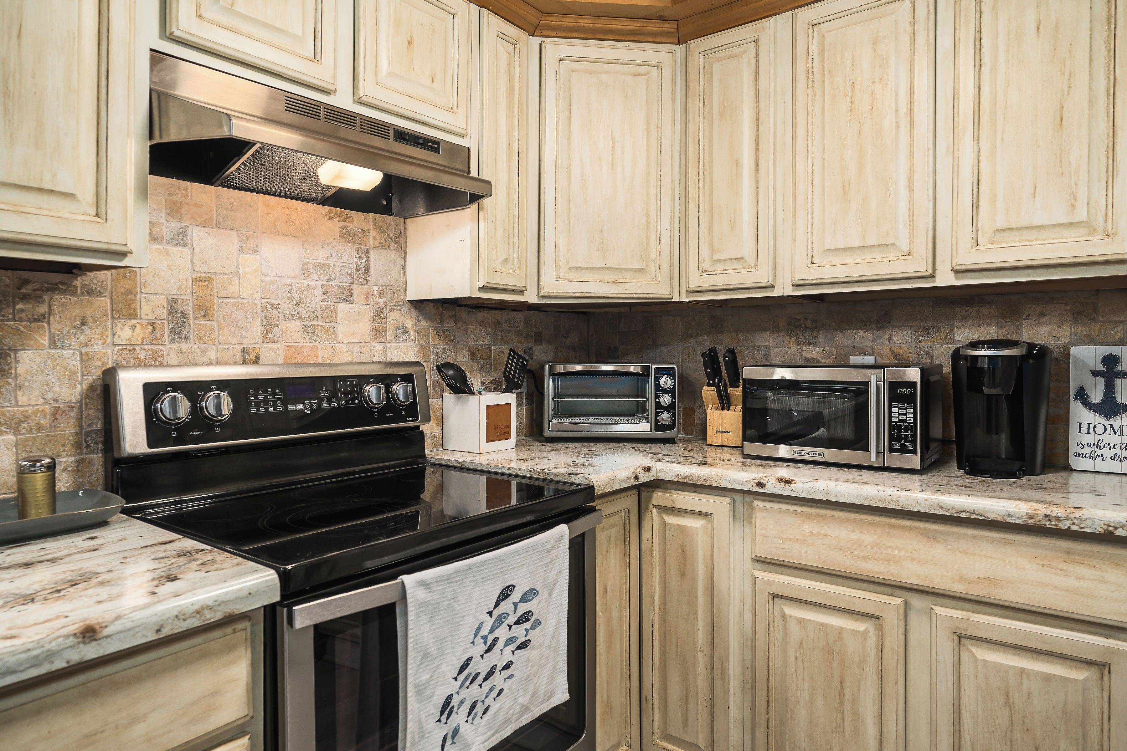 A kitchen with a stove, oven, microwave, and coffee maker.