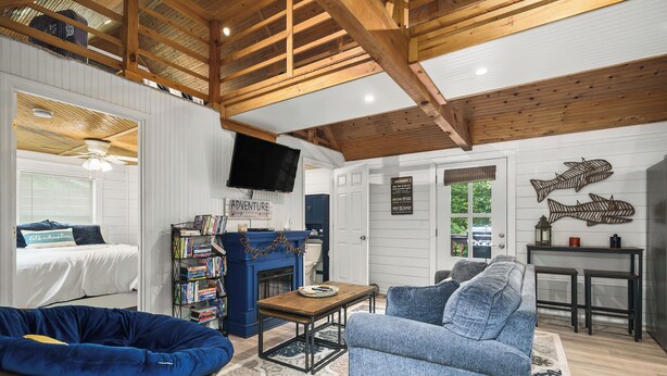 A cozy living room with a blue sofa, a wooden coffee table, and a blue bean bag chair.