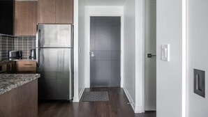 Une cuisine moderne avec des meubles en bois, un réfrigérateur en acier inoxydable et un pare-feu en carreaux.