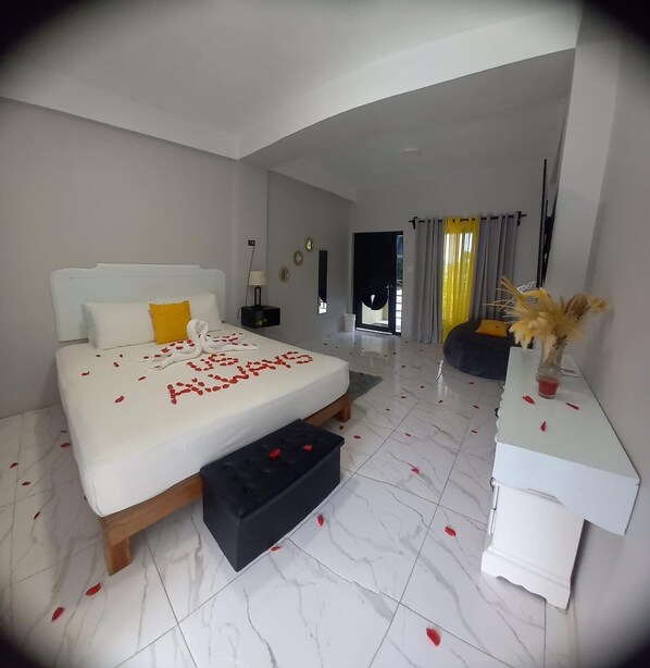 Una habitación de hotel moderna con una cama grande, una mesita de noche, un escritorio pequeño y una silla.