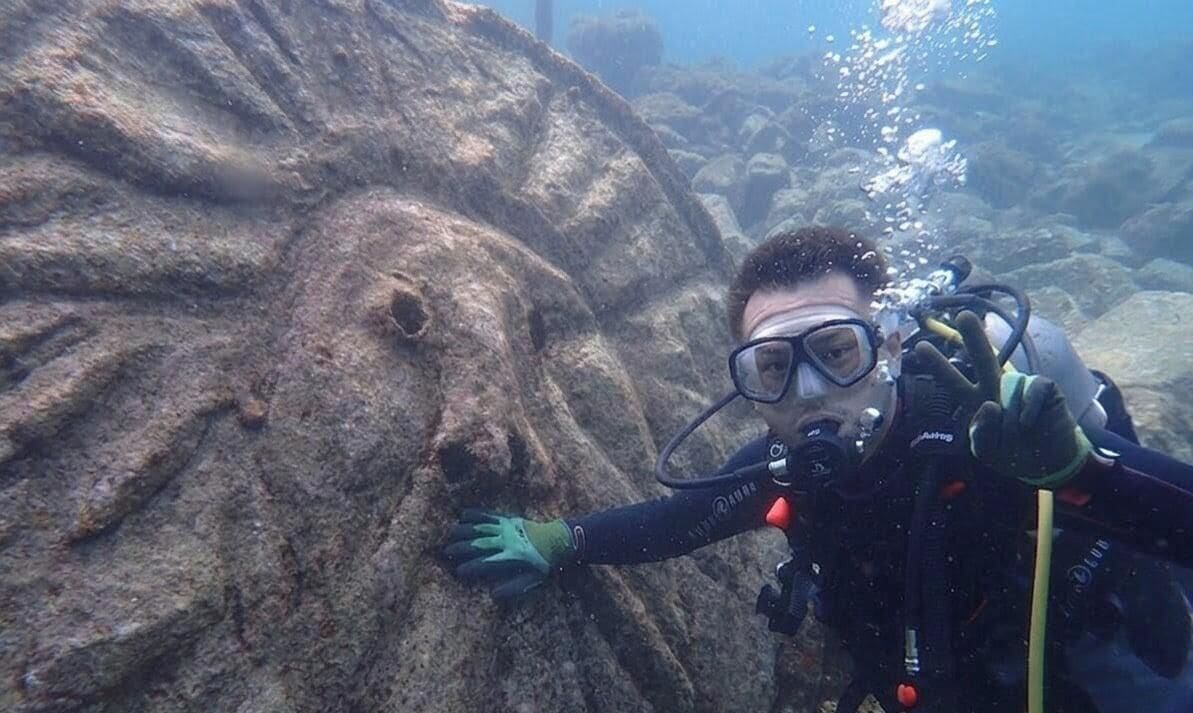 A diver underwater with a rocky environment.