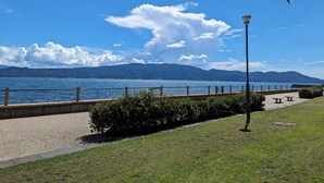 Un passeig marítim amb una vista clara del llac i muntanyes al fons.