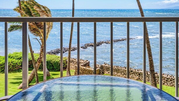 A balcony with a glass table overlooking a rocky shoreline and the ocean. - Beautifully Upgraded, Amazing Ocean Views MS316 (Kihei)