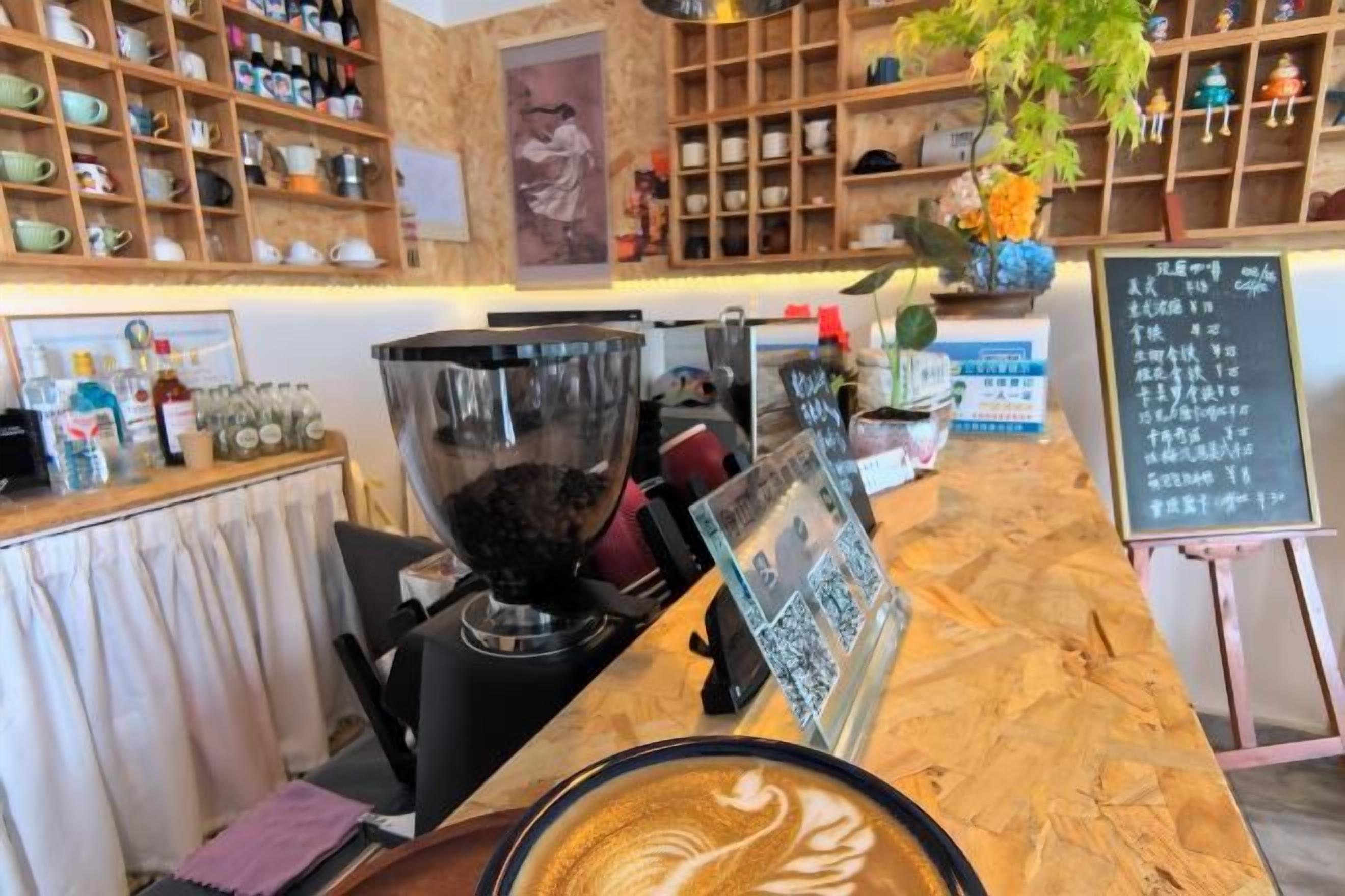 A coffee shop interior with a coffee machine, shelves with various items, and a chalkboard menu.