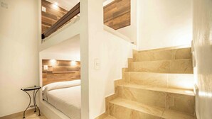 A staircase with beige tiles, a bed with a wooden headboard, and a small table with a lamp. - Spacious House Pool & Jacuzzi (Xochitepec)