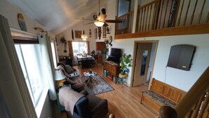 A spacious living room with a large sofa, a dining area, and a kitchen.
