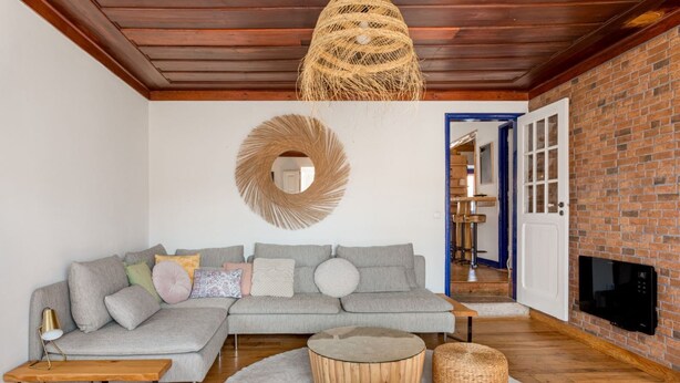 A modern living room with a sectional sofa, a round coffee table, and a fireplace. - Exceptional house near Colares (Colares)