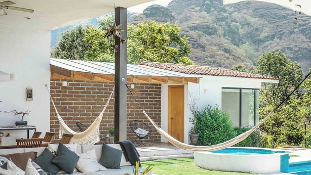 Ein moderner Außenbereich mit Hängematte, Liegestühlen und einem Pool.