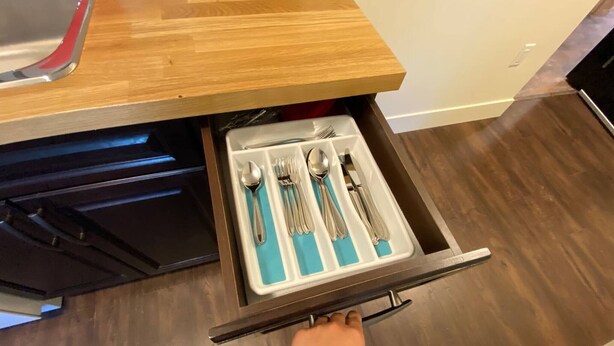 Un cajón con utensilios y una cuchara.