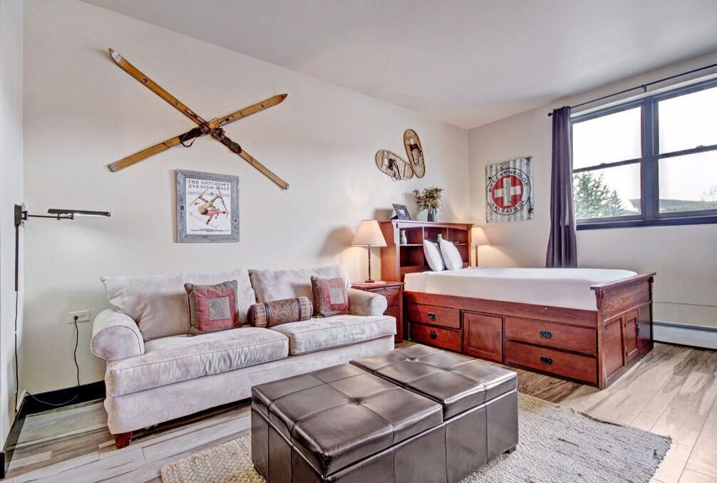 Ein Schlafzimmer mit einem großen Bett, einem Holzschrank, einem Sofa und einem Couchtisch.