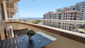 A balcony with a table, two chairs, a potted plant, and a glass of water. - ACV - Acapulco IV-1st floor line 4 South (OROPESA)