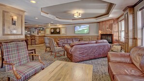 A spacious living room with leather sofas, a wooden coffee table, and a television mounted on the wall. - Spacious 4BR Condo | Year-round Outdoor Fun (Breckenridge)