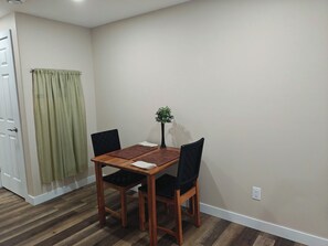 A dining area with a wooden table, black chairs, and a small potted plant. - 1Bed  1Bath Apartment  Quiet, close to park, beach,  biking and walking trails (Arnprior)