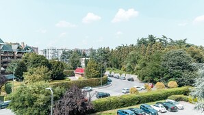 Un parking rempli de voitures, entouré de verdure et de bâtiments.