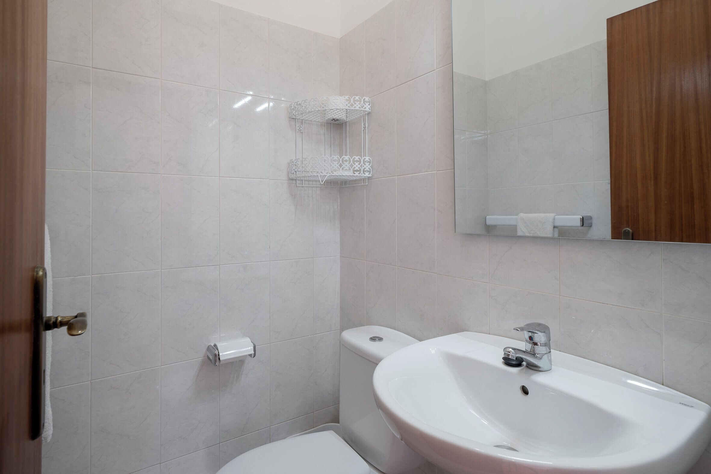 Ein Badezimmer mit Waschbecken, Toilette und Handtuchhalter.