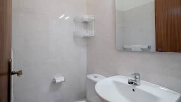 Ein Badezimmer mit Waschbecken, Toilette und Handtuchhalter.