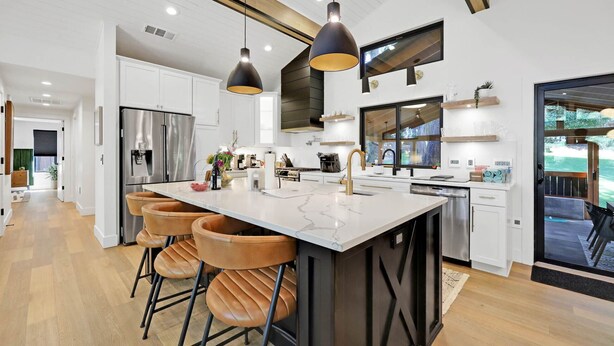 A modern kitchen with a central island, stainless steel appliances, and pendant lighting. - Eugene Evergreen Escape by Les Chalets Stays is a fully renovated home perfect for your crew! Game room, play house, sauna, outdoor entertaining space and huge back yard. (Eugene)