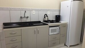 Una cocina compacta equipada con estufa a gas, microondas y refrigerador.