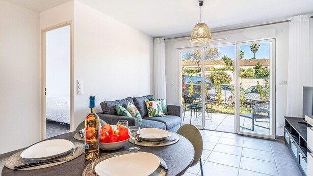 A modern living room with a dining area, a sofa, and a TV. - Eden Golfe by Interhome (Cogolin)