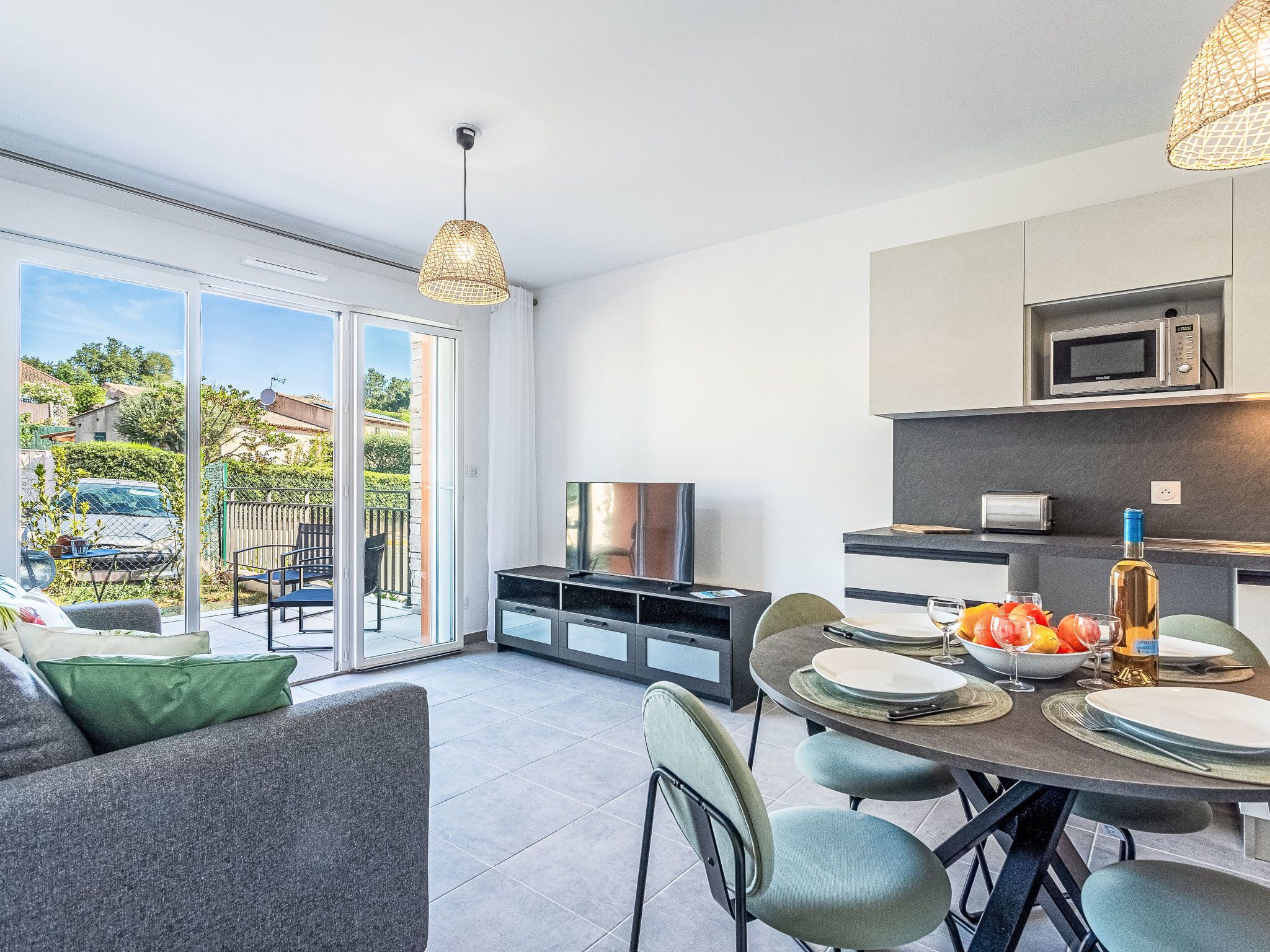 A modern kitchen with a microwave, toaster, and dining table set for six.