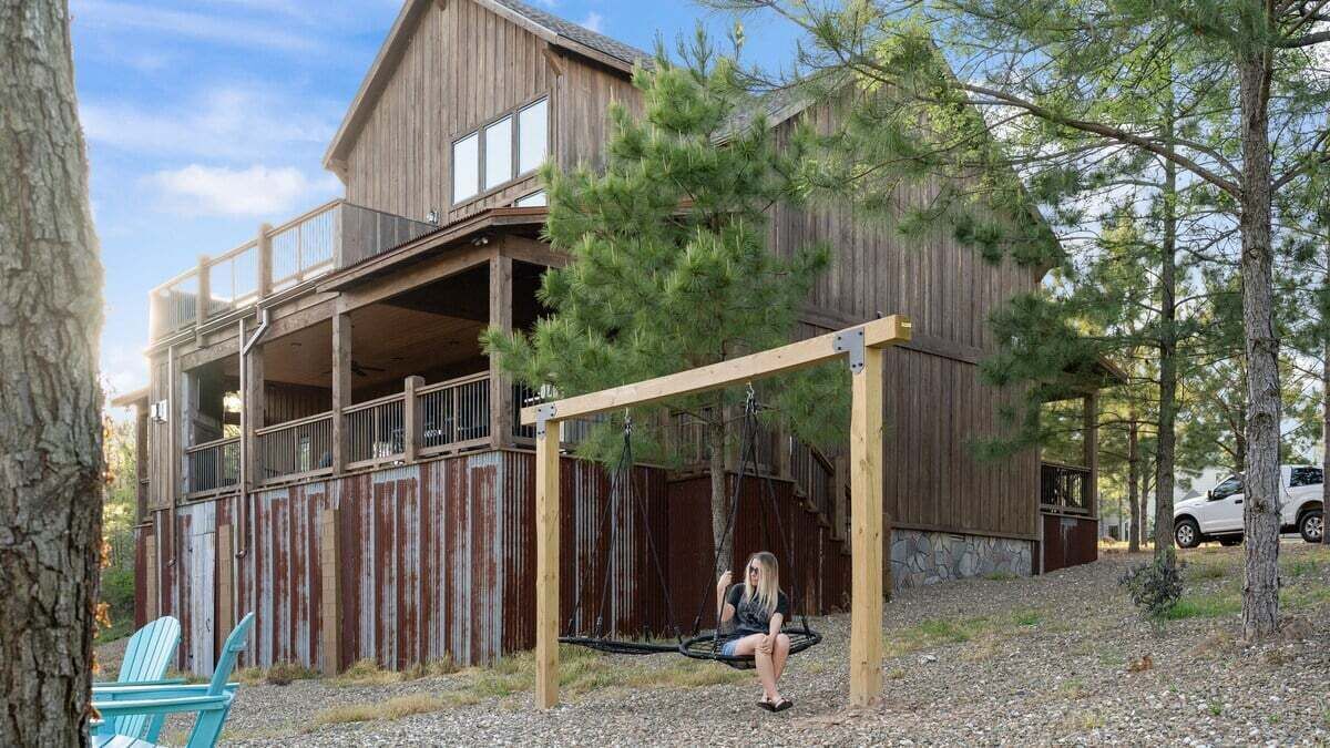 A rustic wooden building with a porch and a swing.